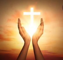 Cupped hands and setting sun with cross of light